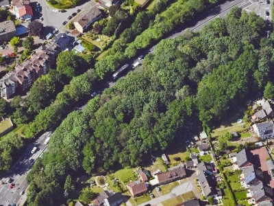 Luftbild eines Stadtgebiets mit einem großen grünen Baumareal in der Mitte