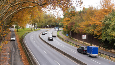 Foto einer Bundesstraße, mehrere Autos fahren durch eine Kurve